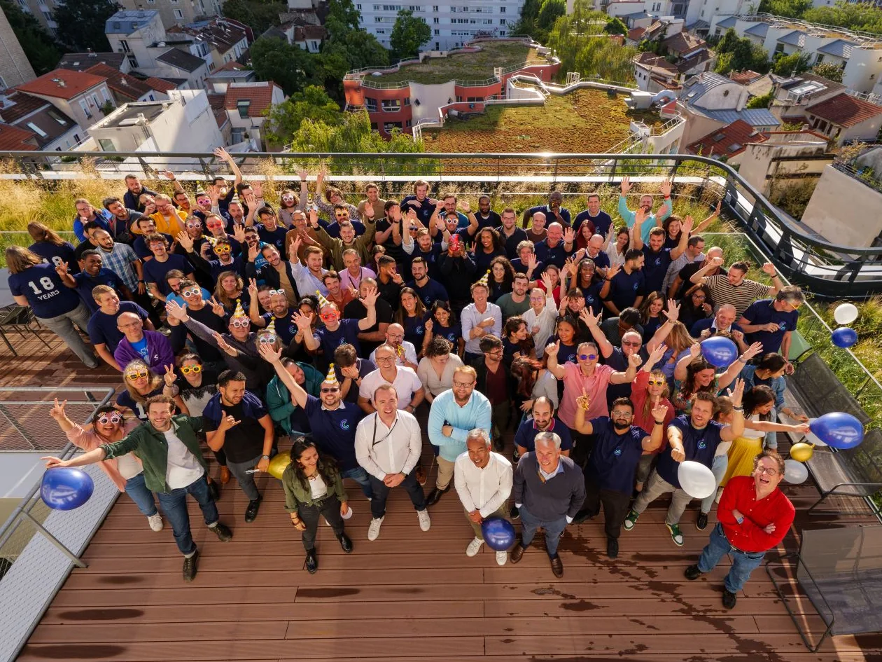 L’équipe Centreon réunie sur un toit-terrasse à Paris, saluant l’objectif